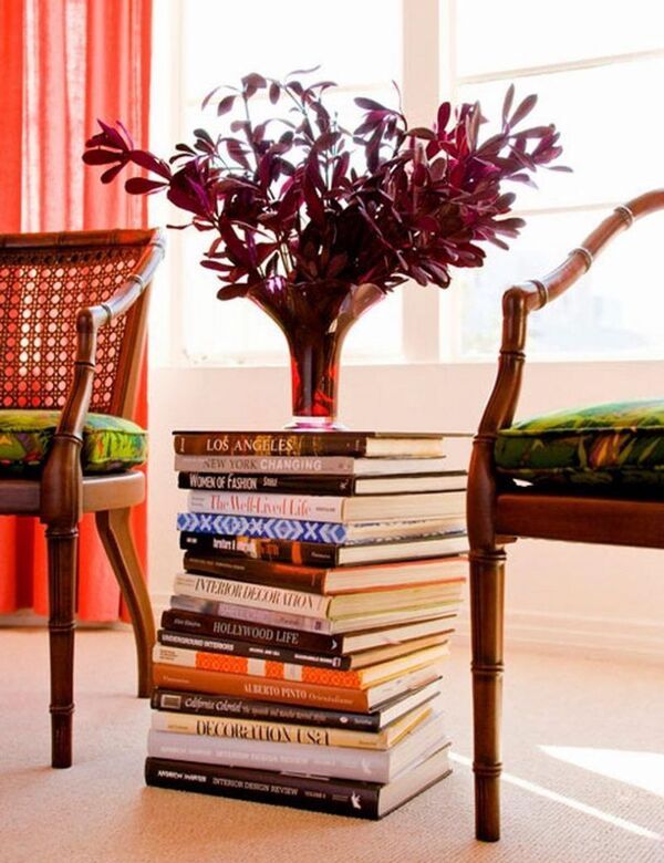 Stack of books on a side table next to a chair